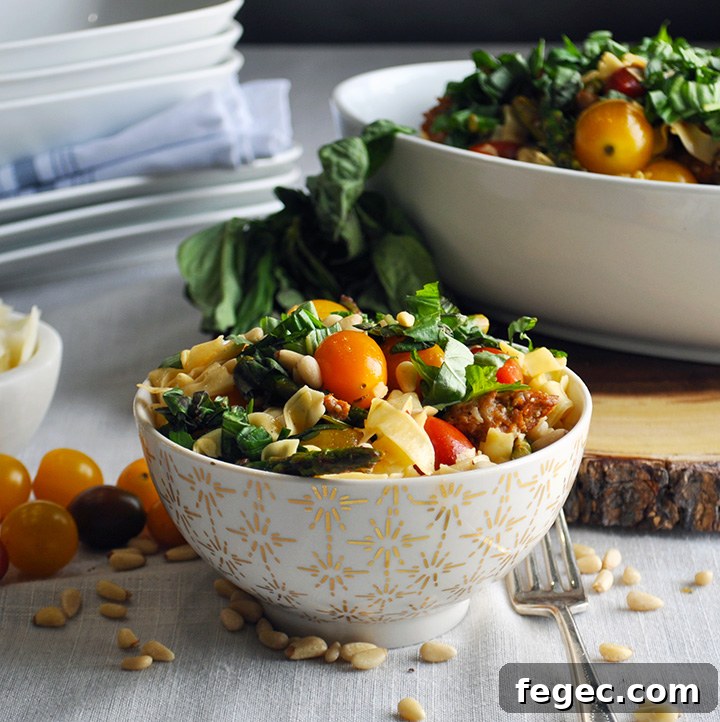 A bowl of pasta with sausage and vegetables.