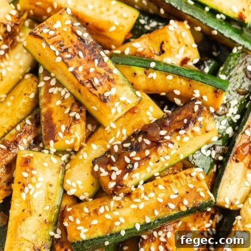 Grilled zucchini stacked and topped with sesame seeds