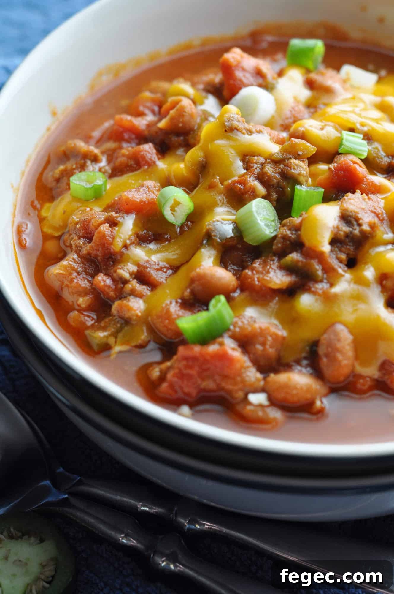 Served chili with cheese and green onions