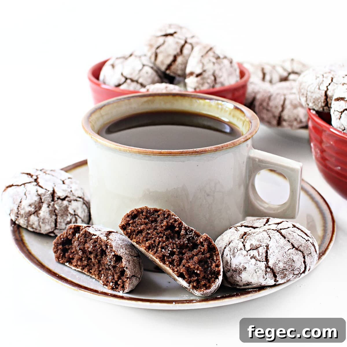 Chewy Almond Flour Chocolate Cookies with cocoa, shown broken in half with soft crumb inside, on a saucer with coffee.