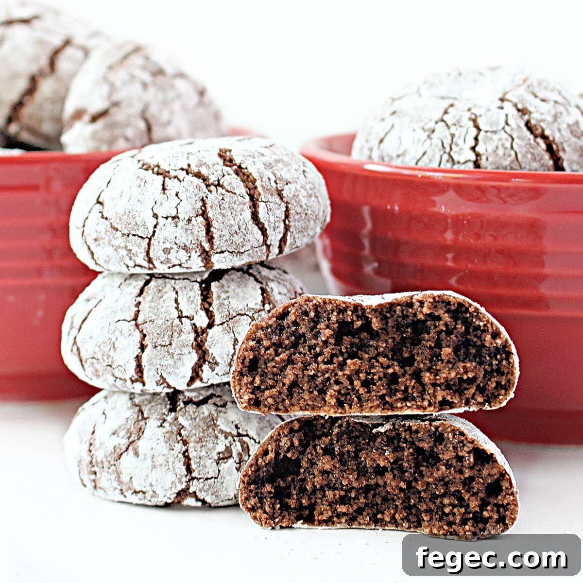 Stack of almond flour cookies with one thick cookie split in half showing chocolate crumb inside.