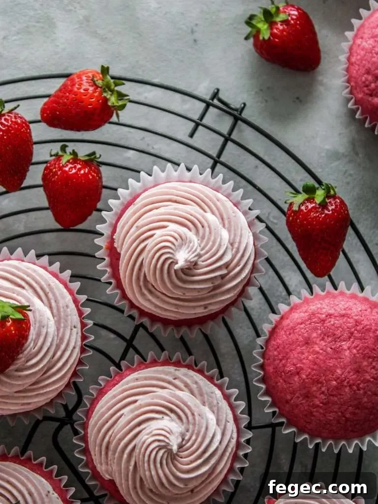 strawberry ermine frosting piped onto strawberry cupcakes on wire rack (2)