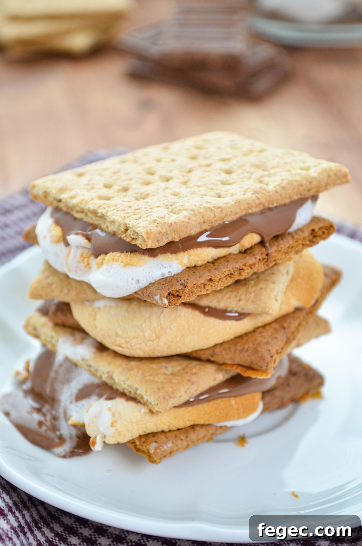 A stack of three s'mores on a white plate.