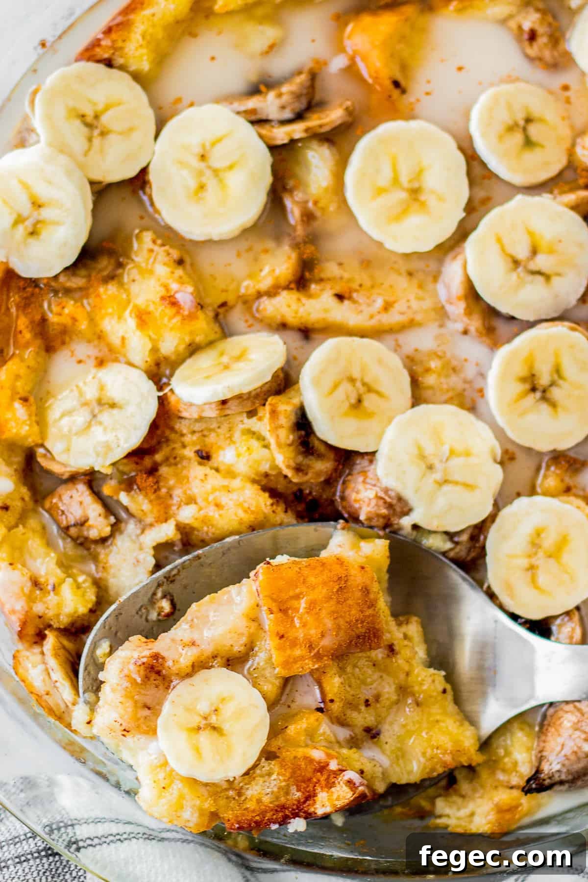 overhead view of freshly baked banana bread puffing in a baking dish with a serving spoon.