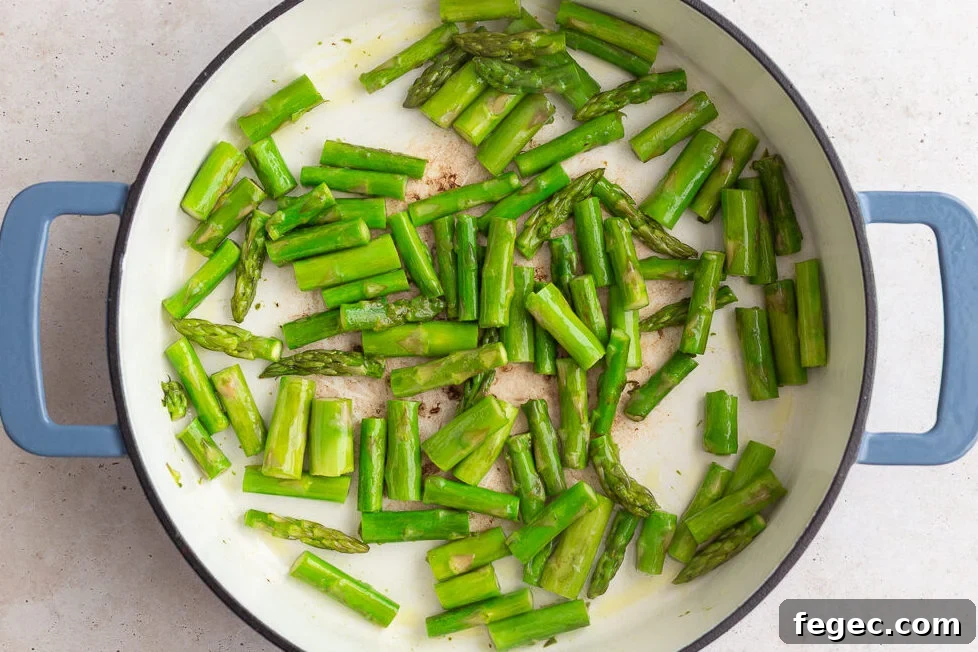 asparagus pieces sauteeing in a large skillet