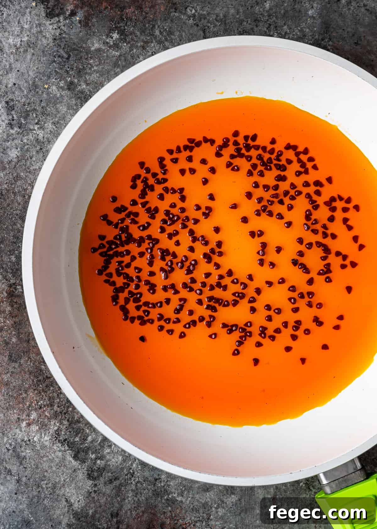 annatto seeds steeped in oil in frying pan