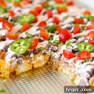 Creamy cheesy Tatchos recipe! Tater tot nachos are layered meat, cheese, and a delicious creamy drizzle!