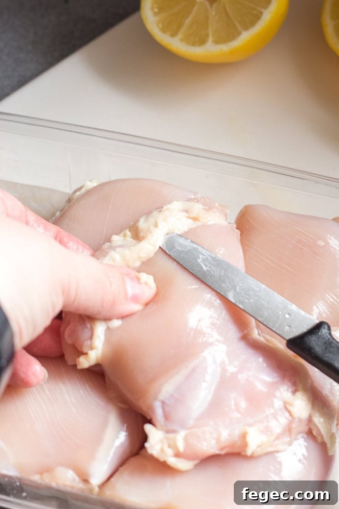 trimming fat off a chicken thigh