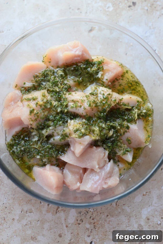 Marinade in a bowl with cubed chicken.