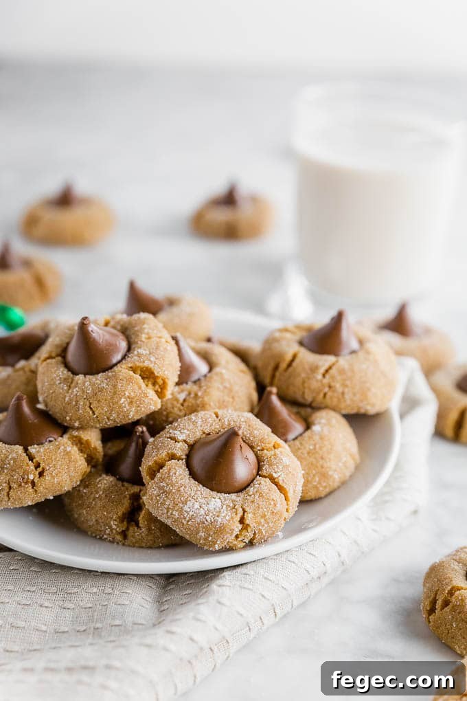a plate of chocolate peanut butter blossoms with a glass of milk