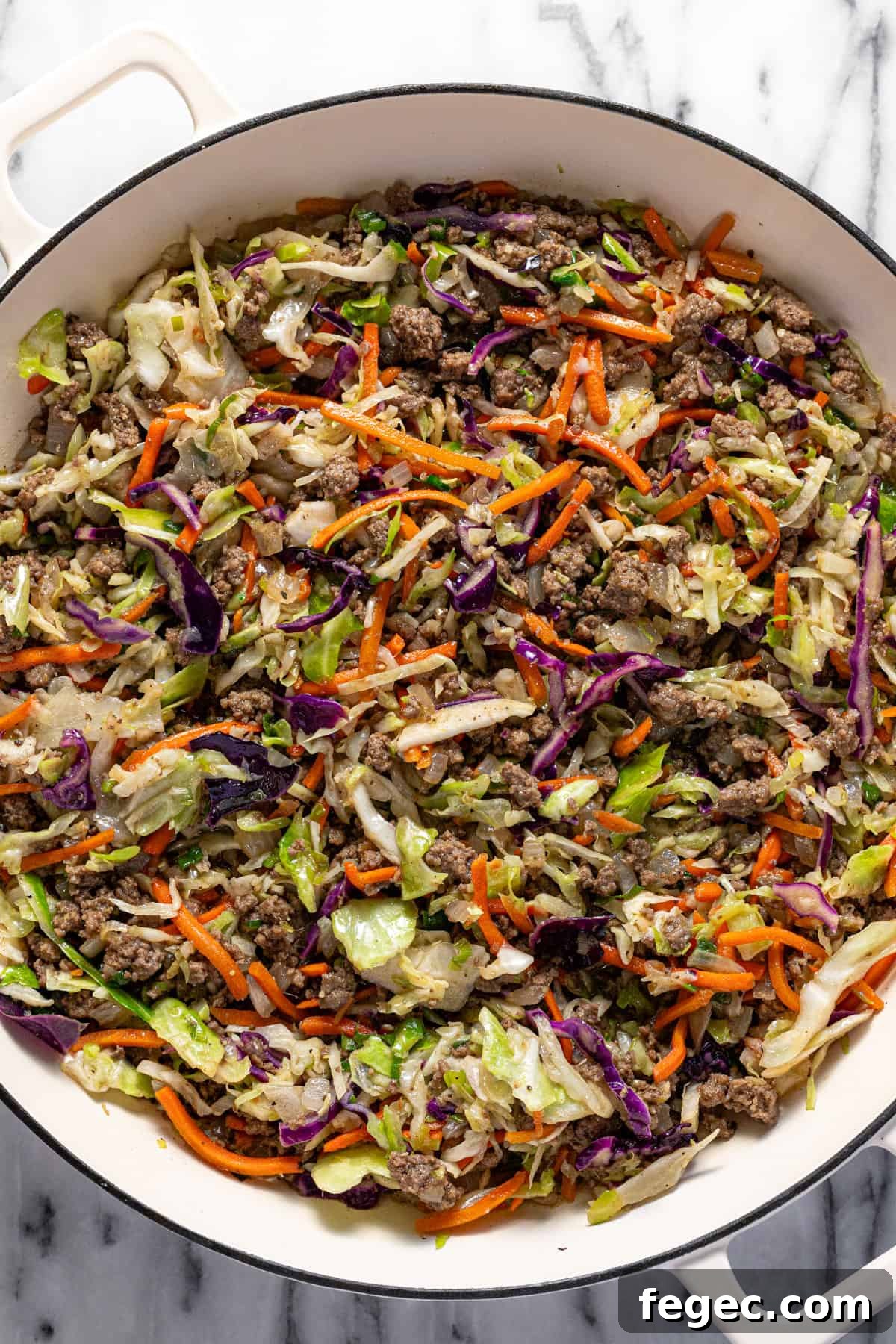 Large white pan filled with homemade egg roll in a bowl mixture.