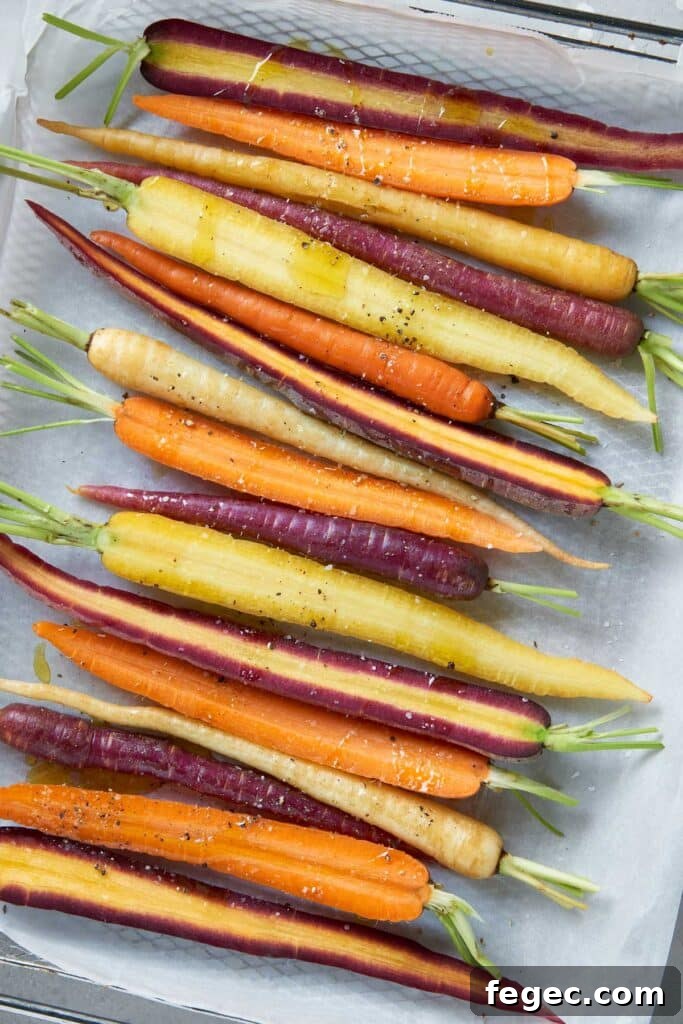 Rainbow carrots tossed with oil, salt and pepper on a parchment-paper lined pan