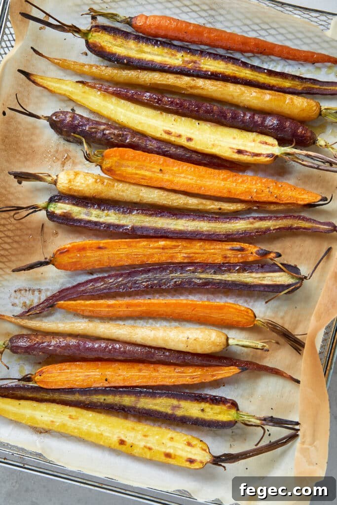 Caramelized roasted multi-colored carrots on a parchment paper lined pan