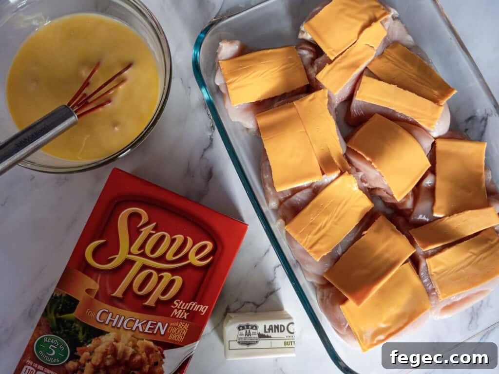chicken in 9x13 pan with cheese slices on top, cream soup and milk in a bowl, and a box of stuffing